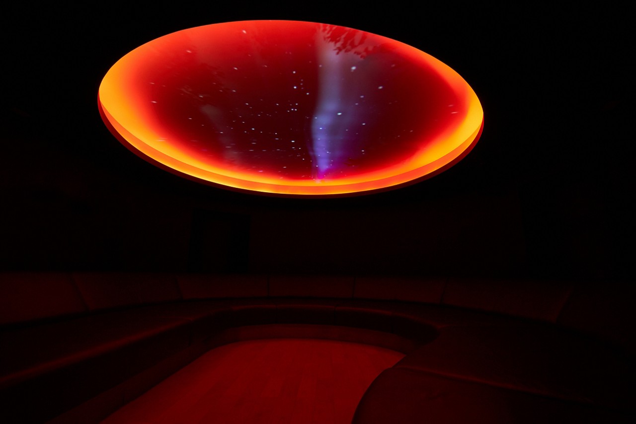 Forest Meditation room lined with comfortable seating and a glowing glass dome on the ceiling.